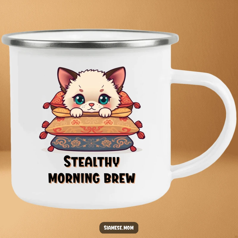 Funny Siamese cub peeking from behind cushions, a cute kitten ready for adventure on a durable camping mug.