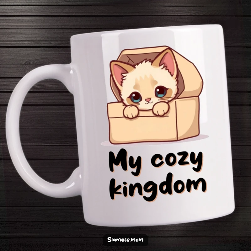 Funny Peek-a-Boo Mug: A kawaii Siamese kitten with curious eyes peeking over the edge of a soft, patterned box.