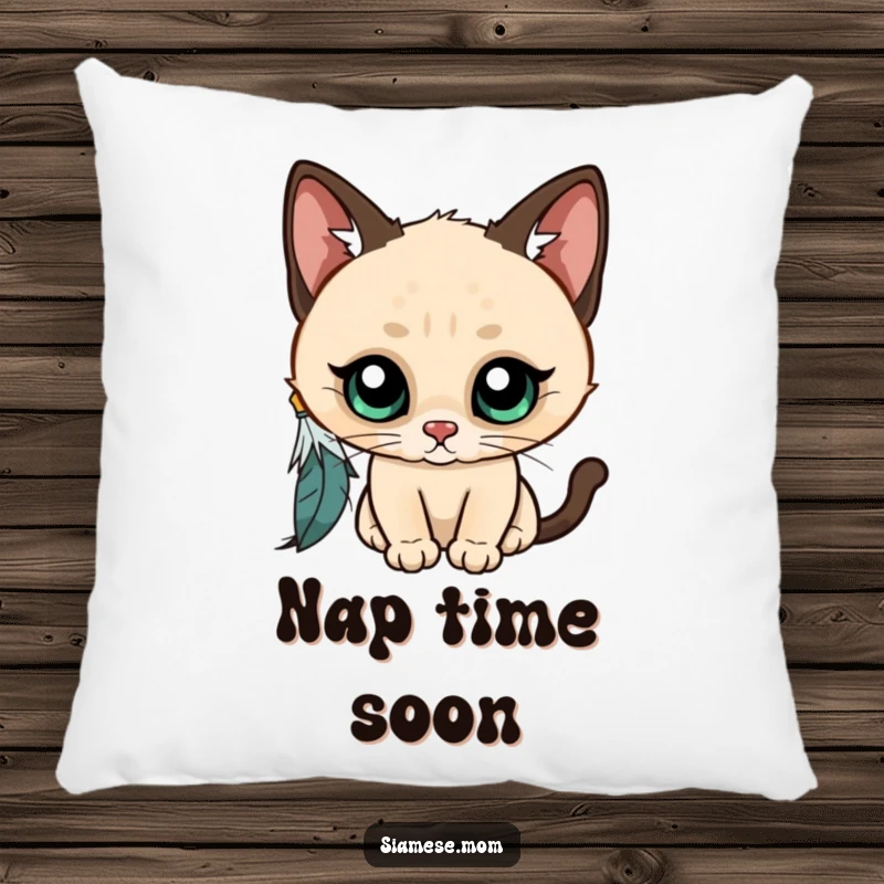 Funny Kawaii Siamese cat pillow, wide-eyed and curious, batting at a dangling feather, a soft and humorous decorative accent.