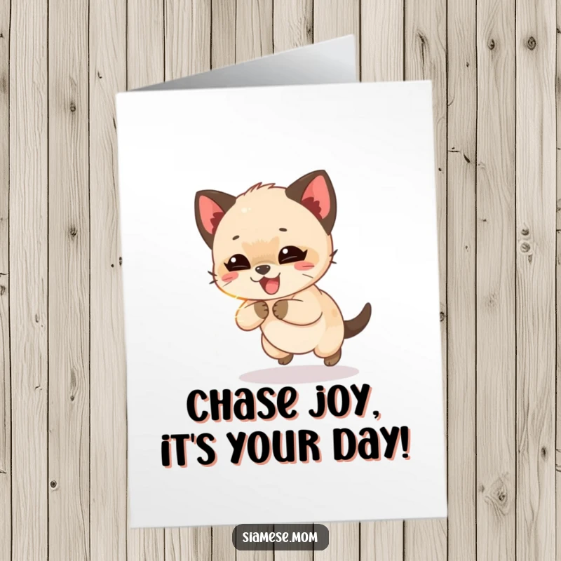 Funny Free Printable Birthday card with a giggling Siamese cub joyfully chasing a shimmering light beam.