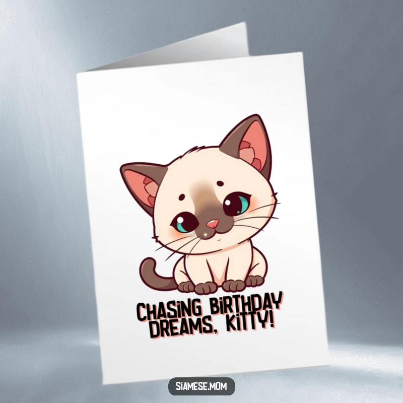 Funny Free Printable Birthday Card: Kawaii Siamese cat tilts head quizzically, captivated by a dancing laser dot, full of wonder.
