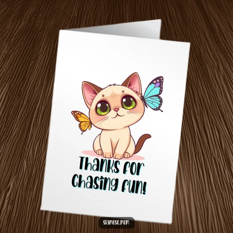Funny free printable thank you card: Kawaii Siamese cat with wide eyes looking grateful as it bats at a butterfly.