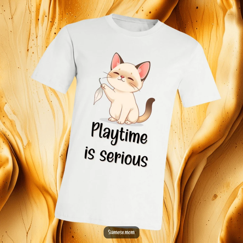Funny Siamese Cat T-Shirt: A Siamese cat intently bats at a feather drifting down, highlighting playful energy and focus.