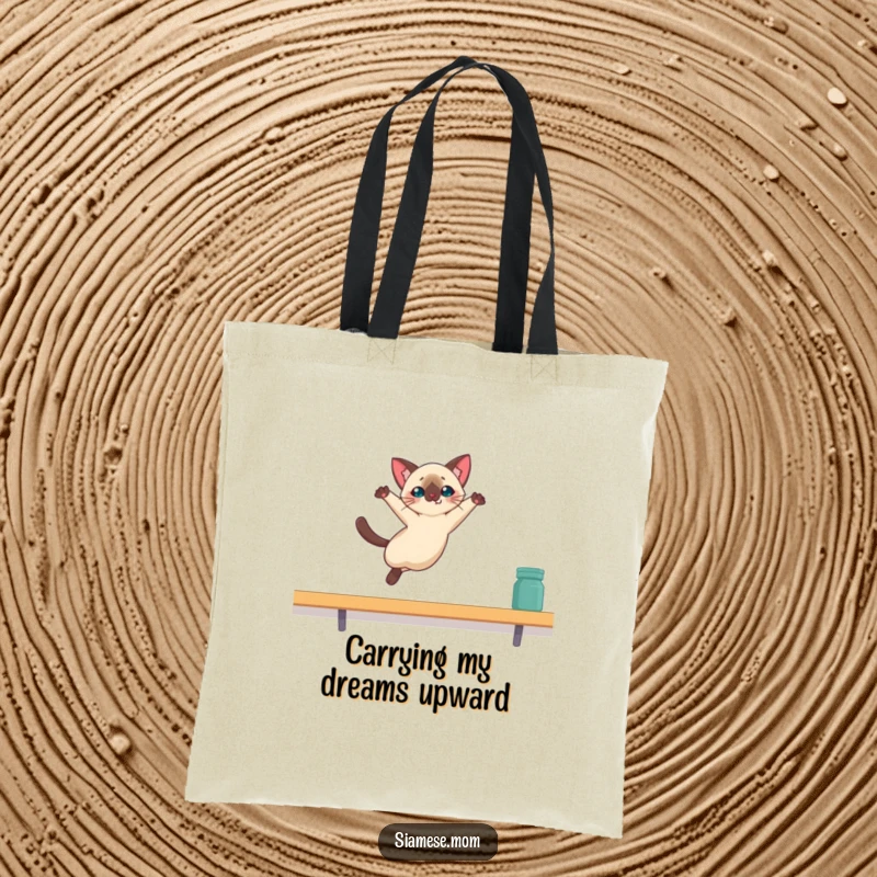Funny Kawaii Siamese cat tote bag illustrating a cat mid-leap, aiming for a high shelf with hilarious determination.