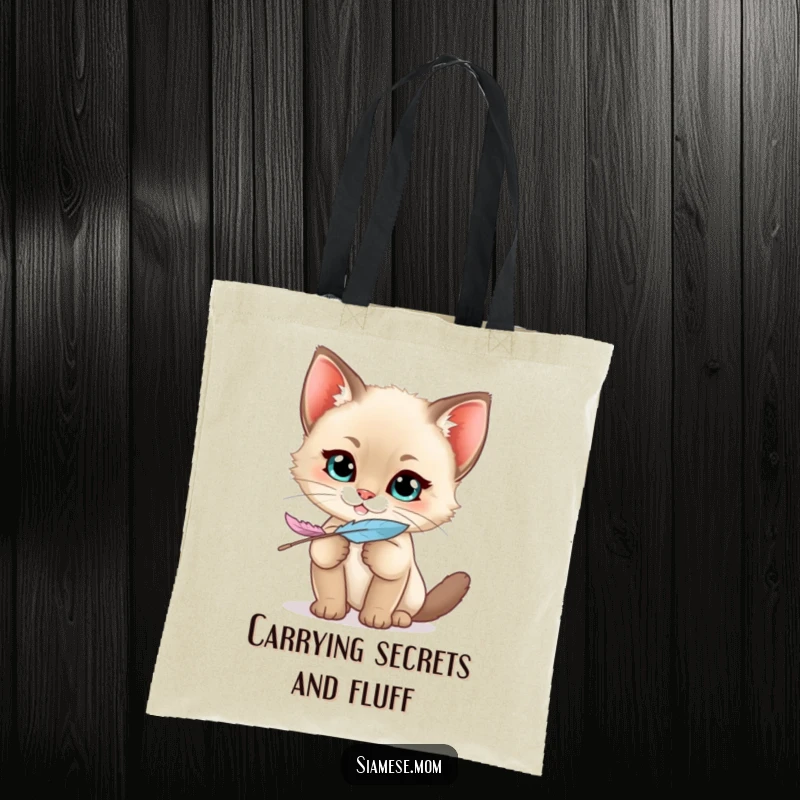 Funny Siamese Kitten Tote Bag displaying a kawaii cat with a mischievous grin holding a feather, ideal for stylish, playful outings.